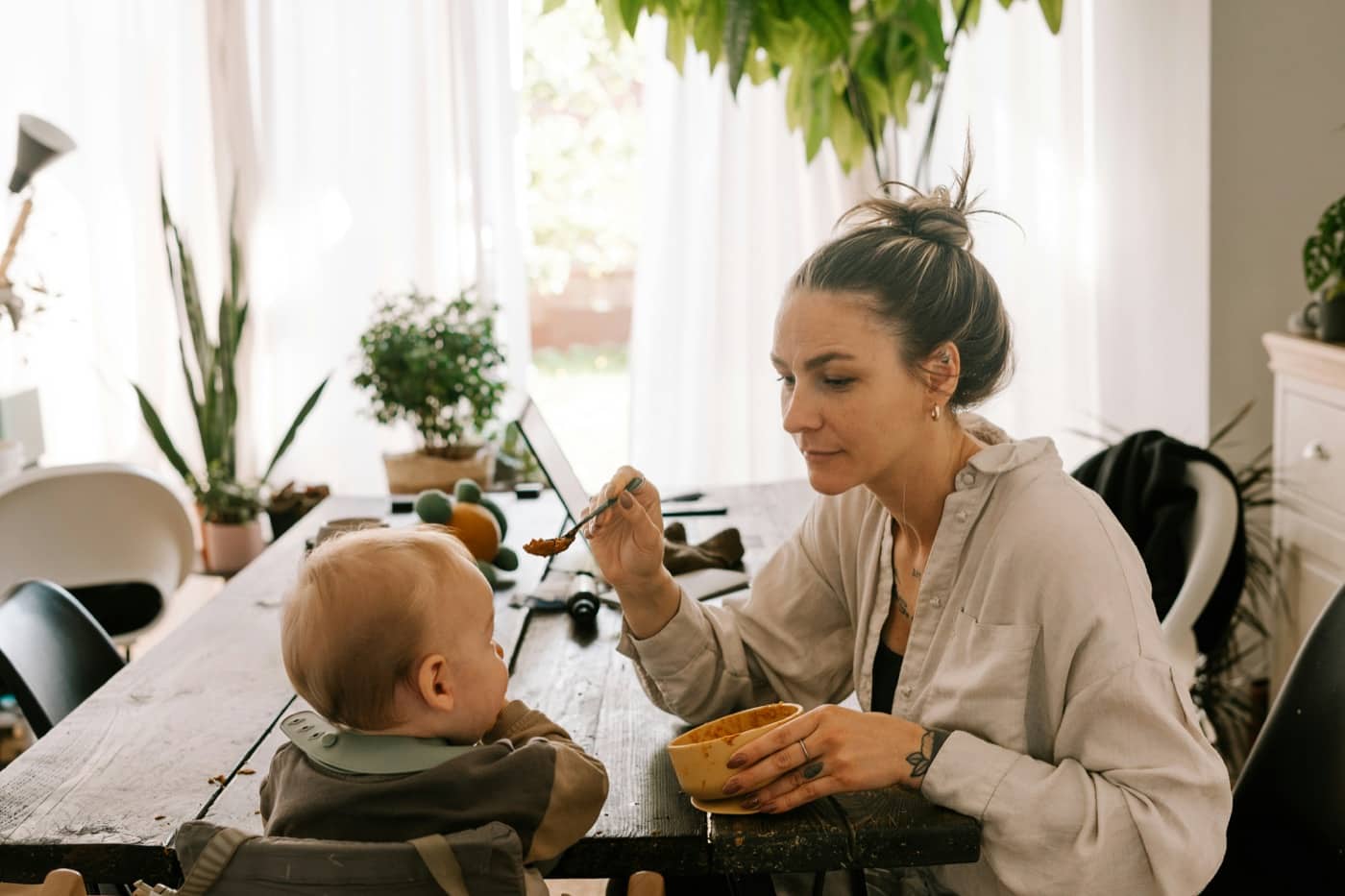 A parent feeding a baby during a quiet everyday moment.