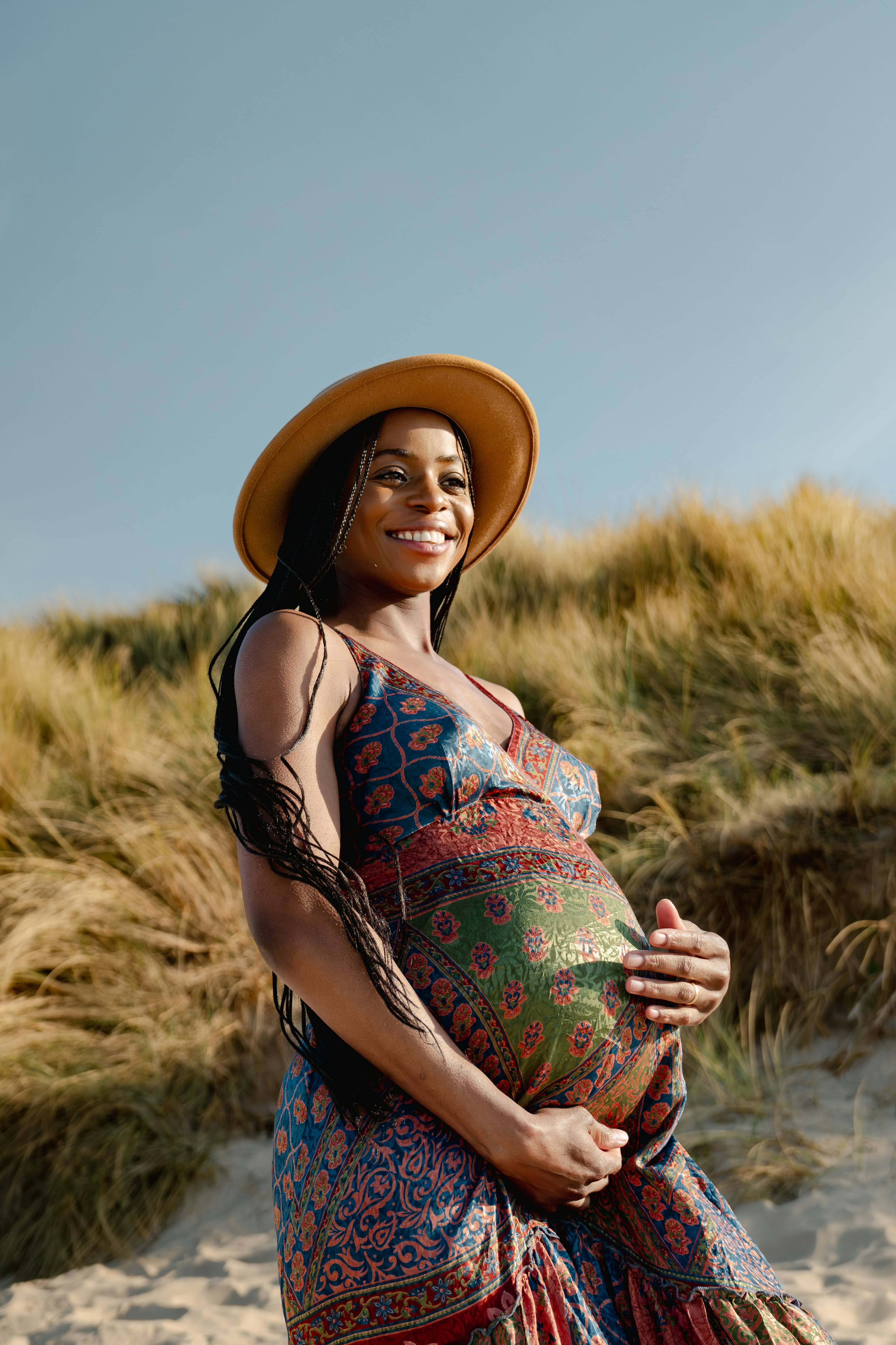 A pregnant parent resting in soft natural light.